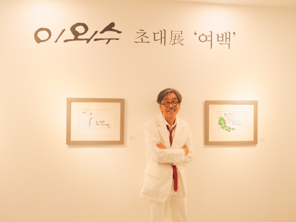 이외수 작가가 ‘선화·캘리그라피 초대전 '여백'’ 전시회서 자신의 작품과 함께 촬영에 임하고 있다 (사진=전진홍 기자)