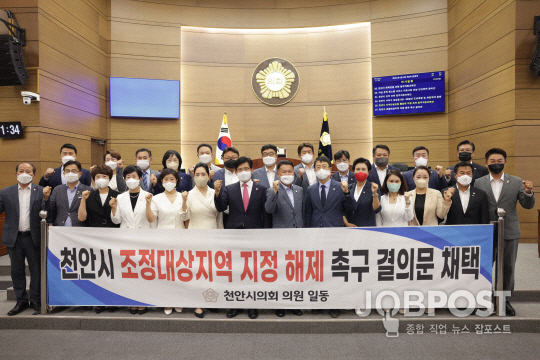 사진_지난 20일 천안시의회 의원들이 조정대상지역 지정 해제 촉구 결의문 채택 뒤 기념촬영하고 있다.