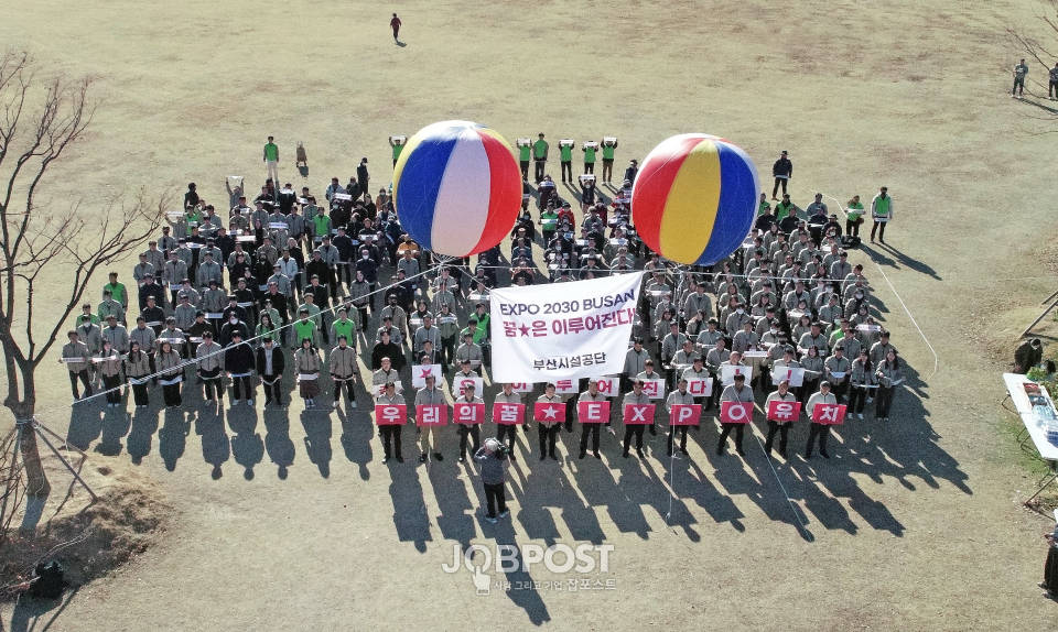 24일 오후 2시 공단이 부산시민공원 잔디광장에 띄운 애드벌룬을 배경으로 공단 임직원과 시민 330여 명이 참가자들은 응원의 함성을 지르고 있다.(사진_부산시설공단)