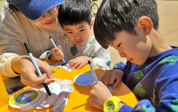지난 26일 가족과 함께 익산시 서동공원을 찾은 두 형제는 엄마와 함께 정성스럽게 평화의 메세지를 작성하고 있다. (사진=유유례 기자)