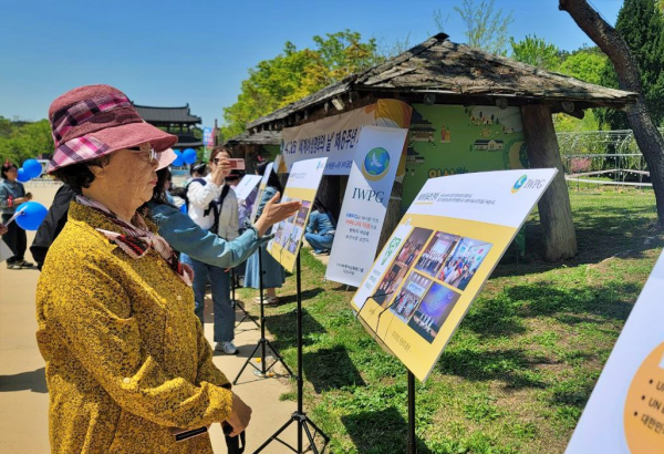 지난 26일 가족과 함께 익산시 서동공원을 찾은 어르신은 IWPG 평화활동을 열정적인 시선으로 바라보고 있다. (사진=유유례 기자)