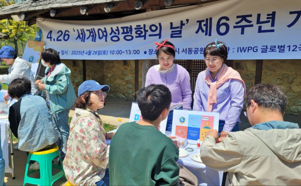 지난 26일 서동공원을 찾은 한 가족이 평화를 염원하며 즐겁게 소원팔찌를 만들고 있다.(사진=유유례 기자)